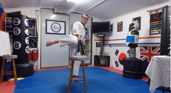 Man doing a Roundhouse and Hook Kick inside a gym